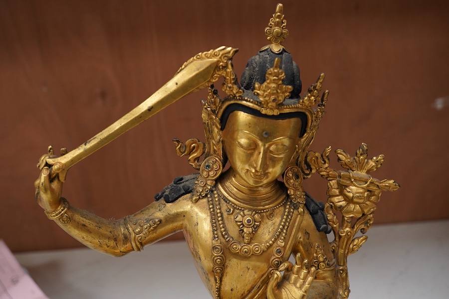 A gilt bronze figure of Manjushri, 31cm